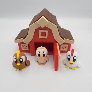 May include: A red barn with a brown roof and three cartoon chicks. The chicks are brown, beige, and white with yellow and orange details. The barn has a red door and beige trim.