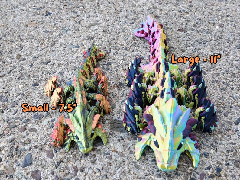 May include: Two colorful, 3D printed dragon figurines. The larger dragon is 11 inches long and the smaller dragon is 7.5 inches long. Both dragons have a green, yellow, orange, and black color scheme.