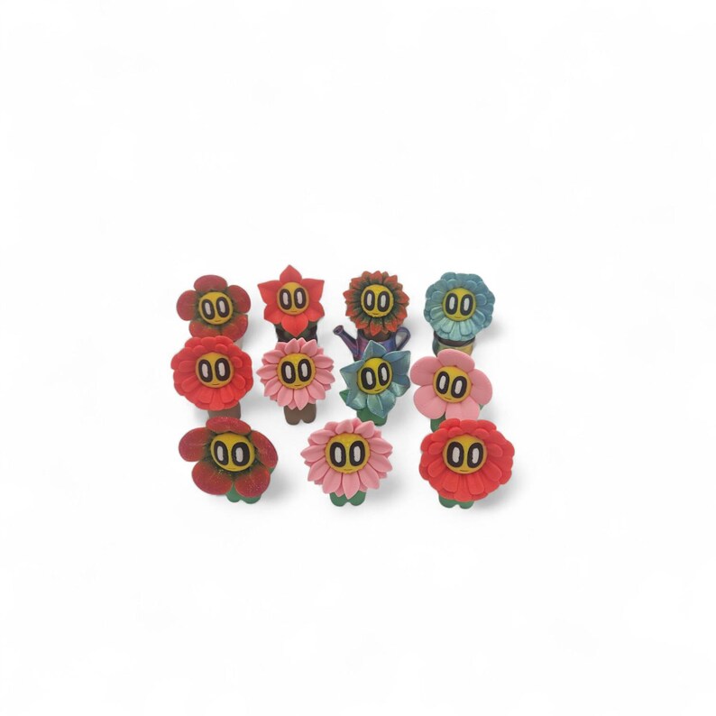 May include: A collection of eleven colorful flower-shaped decorative objects. Each flower has a different color, including red, pink, blue, and yellow, with the number "00" in the center of each flower. The objects are arranged on a white background.