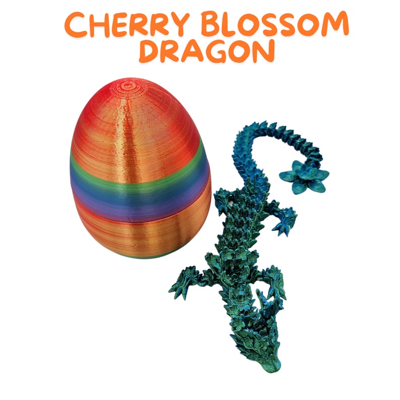 May include: A rainbow-colored egg with a blue and green dragon figurine. The dragon has a flower on its head. The text "CHERRY BLOSSOM DRAGON" is written above the egg.