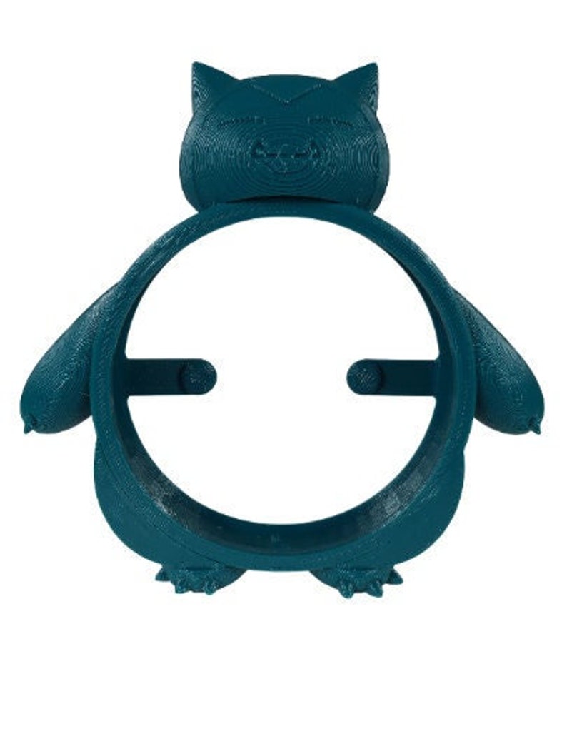 May include: A teal blue 3D printed Pokemon character, Snorlax, with a round opening in the center. The character is designed to hold a phone or other small device.