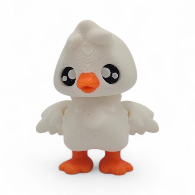 May include: A white 3D-printed duck figurine with an orange beak and feet. The duck has large, black eyes and small wings. The figurine is standing upright and has a smooth, textured surface.