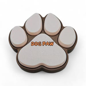 May include: A brown and white dog paw-shaped object with the text "DOG PAW" in orange. The paw has five white pads and a brown outline. The object is likely a decorative item or a pet-related product.