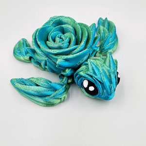 May include: A teal and green 3D printed turtle figurine with a rose-shaped shell.