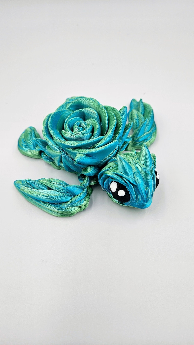 May include: A teal and green 3D printed turtle figurine with a rose-shaped shell.