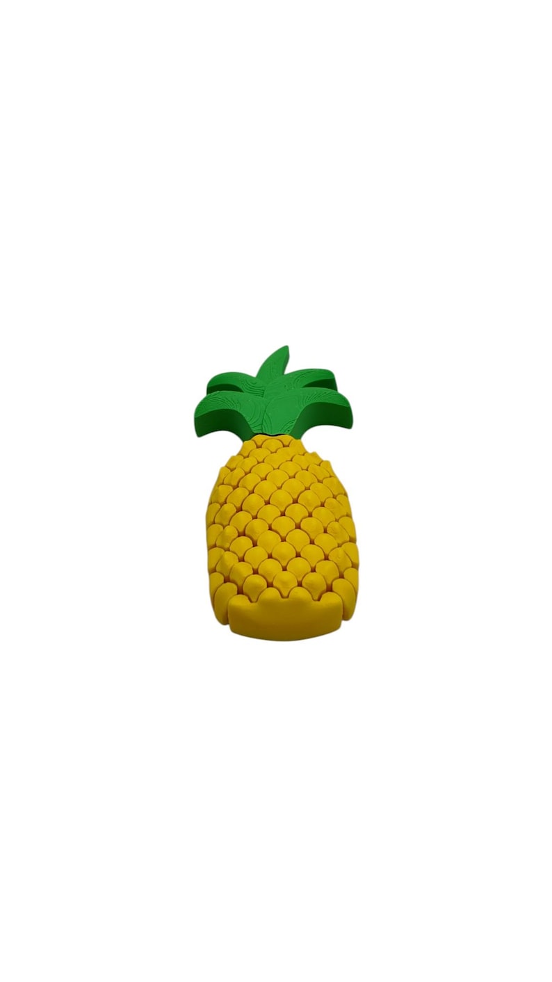 May include: A yellow pineapple-shaped object with a green leafy top. The pineapple has a textured surface and is set against a white background. This decorative item is a tropical fruit-themed product.