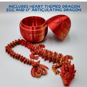 May include: A red heart-themed dragon egg with a 17-inch articulated dragon. The egg is open and the dragon is partially assembled. The dragon is made of red plastic and has gold accents.