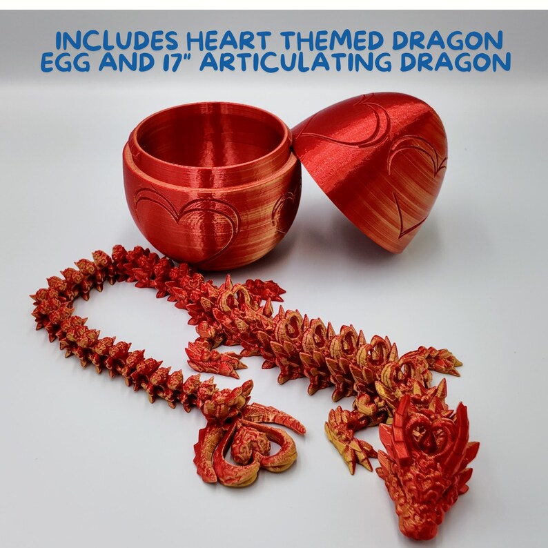 May include: A red heart-themed dragon egg with a 17-inch articulated dragon. The egg is open and the dragon is partially assembled. The dragon is made of red plastic and has gold accents.