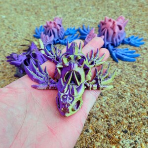 Peut inclure: Un cr&acirc;ne imprim&eacute; en 3D de couleur violette et jaune avec des d&eacute;tails complexes et un design squelettique. Le cr&acirc;ne a une surface textur&eacute;e et semble &ecirc;tre fait de plastique.