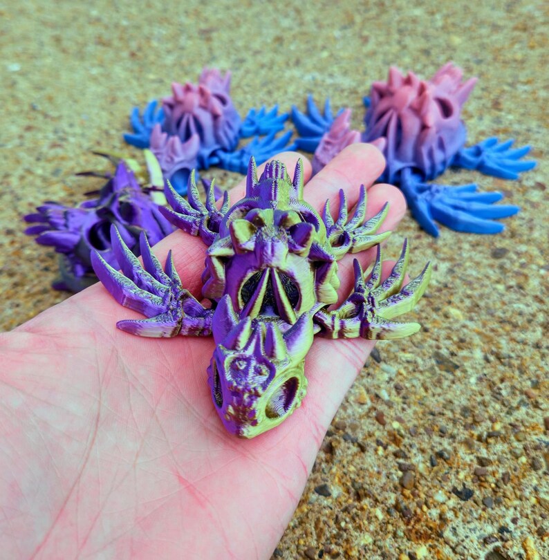 Peut inclure: Un cr&acirc;ne imprim&eacute; en 3D de couleur violette et jaune avec des d&eacute;tails complexes et un design squelettique. Le cr&acirc;ne a une surface textur&eacute;e et semble &ecirc;tre fait de plastique.