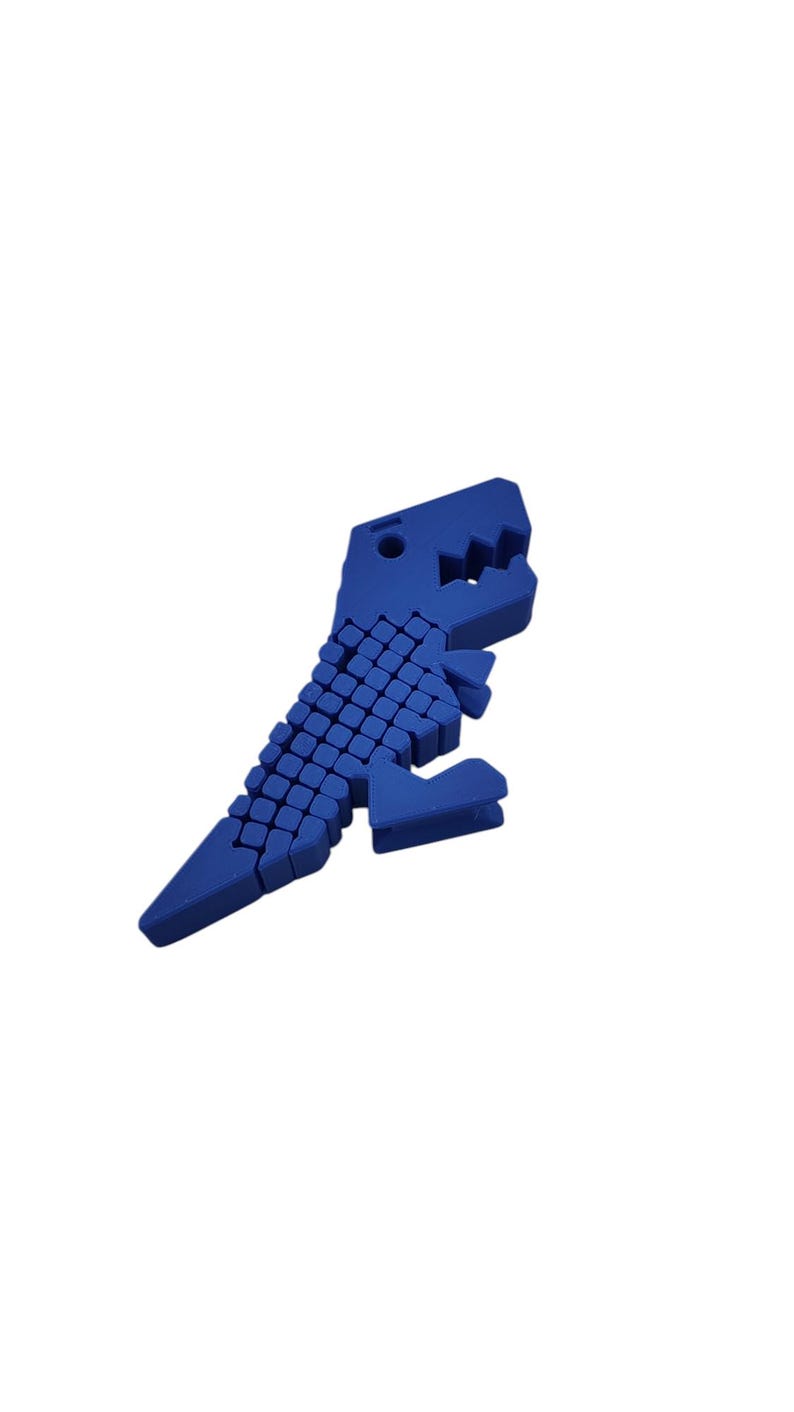 Puede incluir: Un juguete de rompecabezas azul con forma de dinosaurio. El juguete est&aacute; hecho de peque&ntilde;os bloques azules conectados, formando un Tyrannosaurus Rex. El dinosaurio tiene una cabeza detallada con dientes visibles y una cola larga.