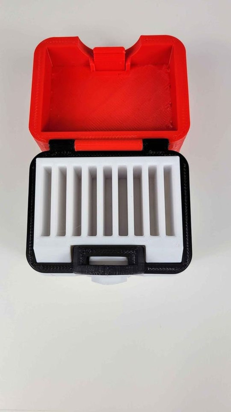 May include: A red and black storage case with a white interior. The case has multiple compartments for holding small items.