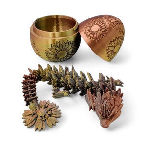 Puede incluir: Una figura de drag&oacute;n articulada, segmentada, con forma de girasol, impresa en 3D. El drag&oacute;n est&aacute; hecho de pl&aacute;stico marr&oacute;n y dorado y est&aacute; acostado de lado. El drag&oacute;n est&aacute; segmentado en muchas piezas, cada una de las cuales tiene la forma de un girasol. La cabeza del drag&oacute;n est&aacute; levantada y sus ojos est&aacute;n cerrados. El drag&oacute;n est&aacute; acostado sobre un fondo blanco.