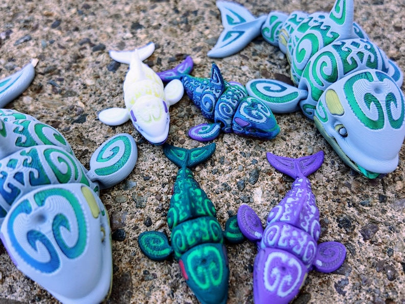 May include: A collection of six small, colorful, plastic sea creatures with a swirling pattern. The creatures are a variety of colors, including green, blue, purple, and white.
