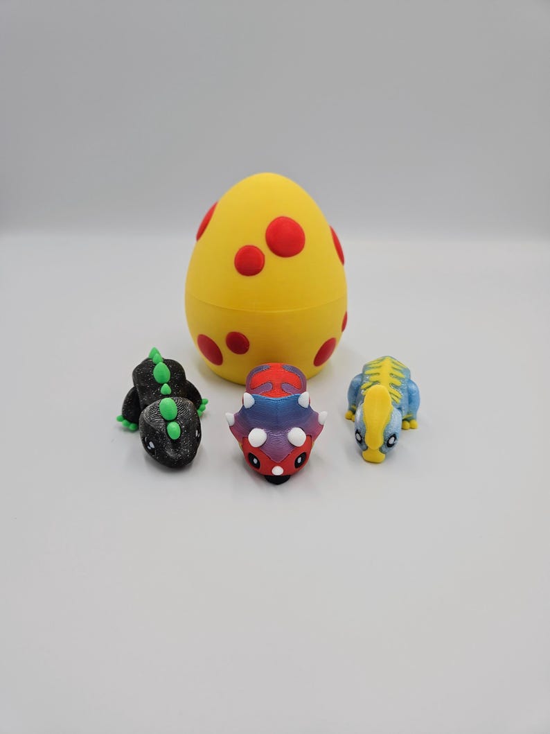 May include: A yellow egg with red spots, and three small dinosaur figurines. The dinosaurs are black, blue, and red and purple.