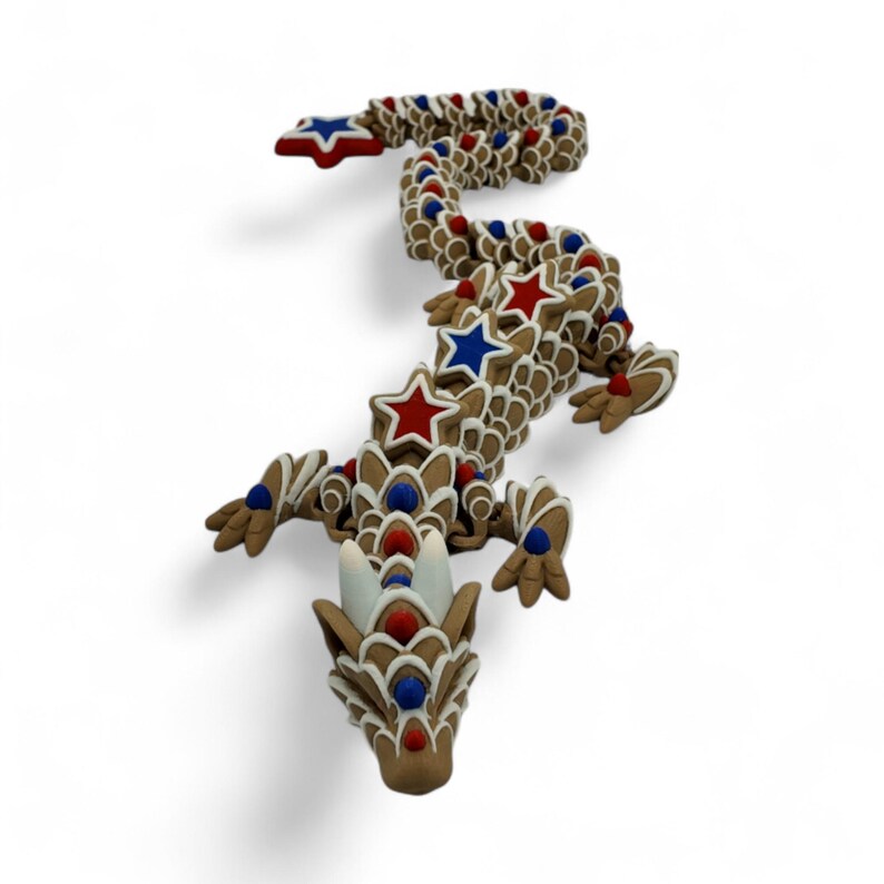 May include: A decorative dragon figurine with a brown body, adorned with red, white, and blue star and dot accents. The dragon's head and tail feature intricate details, creating a whimsical and patriotic design.