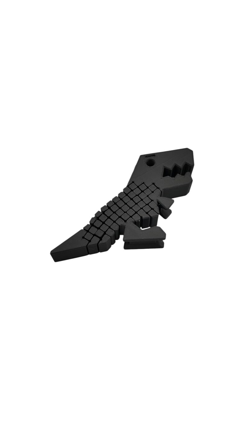 Puede incluir: Una figura de dinosaurio geom&eacute;trico negro. El dinosaurio est&aacute; construido con peque&ntilde;os bloques cuadrados, lo que le da una apariencia pixelada. La cabeza presenta una boca dentada y el cuerpo est&aacute; inclinado, sugiriendo movimiento. El dise&ntilde;o es moderno y minimalista.