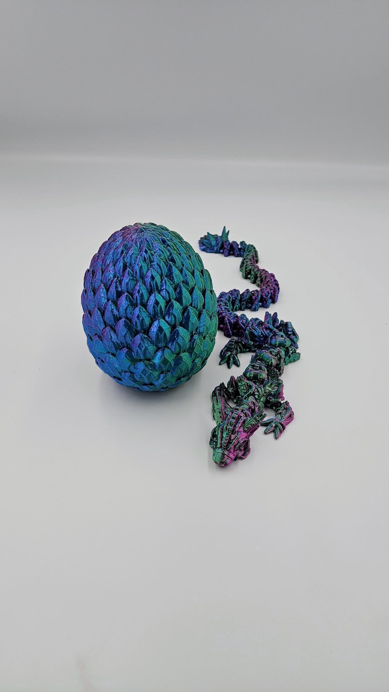 May include: A iridescent blue and green dragon egg with a matching dragon tail made of individual scales.
