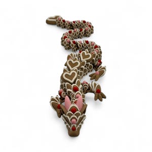 May include: A whimsical, brown gingerbread dragon with white icing details and red and pink accents. The dragon's body is segmented, with heart-shaped elements and decorative features, creating a festive and unique design.