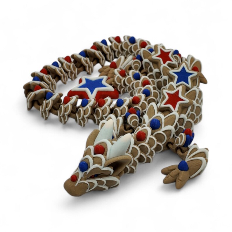 May include: A brown dragon sculpture decorated with red, white, and blue accents. The dragon features star-shaped and round embellishments, with white icing details. The sculpture is designed with a festive, patriotic theme.