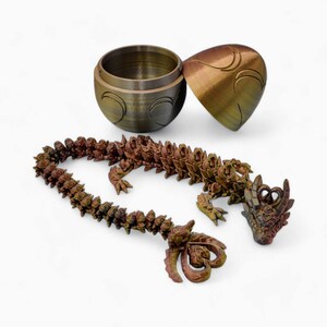 May include: A 3D printed dragon figurine with a segmented body, a detailed head, and a textured surface. The dragon is in a curled position, with its tail wrapped around its body. The dragon is painted in shades of brown and gold.