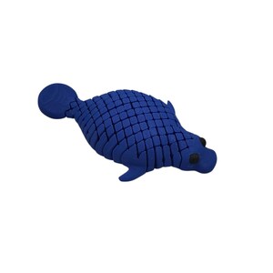 Puede incluir: Una escultura azul estilizada de una foca. La foca tiene un patr&oacute;n texturizado, similar a escamas, en su cuerpo, con peque&ntilde;os ojos negros. La escultura est&aacute; sobre un fondo blanco liso.