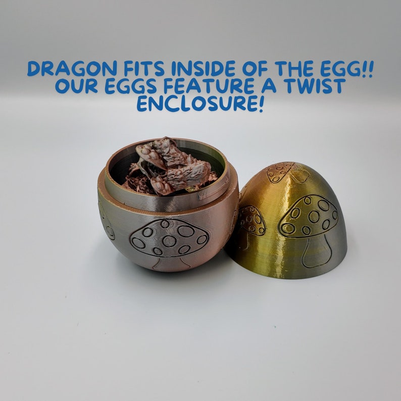 May include: A two-piece, gold and brown, egg-shaped container with a mushroom design. The top half of the container is open and a small, brown, dragon figurine is inside.