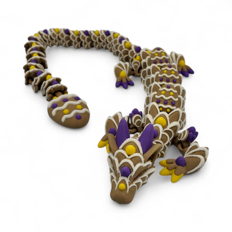 May include: A brown, dragon-shaped sculpture with intricate details. The dragon features a segmented body, with purple, yellow, and white accents. The sculpture has a detailed head, legs, and tail, and is set against a white background.