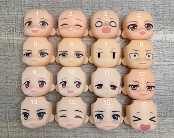 May include: Set of 16 plastic doll heads with different facial expressions. The heads are all light skin tone and have painted features. The heads are numbered 1 through 16.