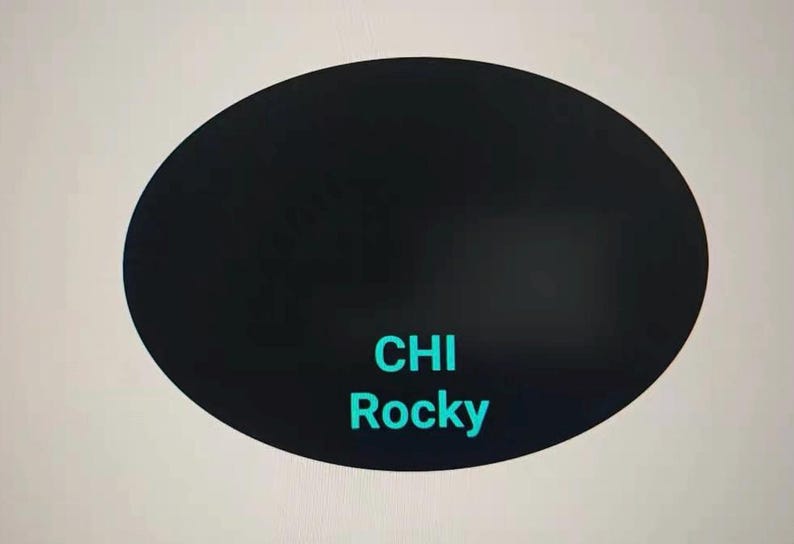 May include: A black oval shape with the words "CHI Rocky" in teal. The background is a light gray color.