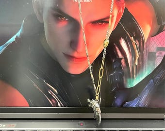 May include: A mixed-metal necklace featuring a silver-toned wolf head pendant suspended from a chain that combines gold-toned elongated oval links with silver-toned twisted bar segments and a small gold-toned bead detail near the top.