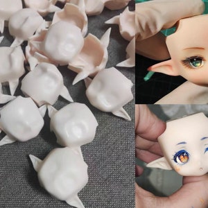 May include: A collection of blank doll heads with elf ears, some are painted with eyes and a mouth. The heads are made of a smooth, white material.