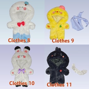 K&ouml;nnte beinhalten: Vier Baby-Outfits aus Pl&uuml;sch mit Tiermotiven. Die Outfits umfassen einen wei&szlig;en Pinguin mit roter Fliege, ein gelbes K&uuml;ken, einen wei&szlig;en Hasen mit lila Schleife und einen schwarzen Vogel. Jedes Outfit hat eine Kapuze und ist mit "Clothes" und einer Nummer versehen.