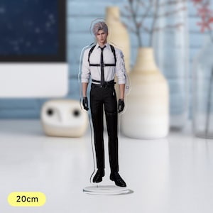 May include: A white shirt with a black harness and black trousers. The figure is standing on a clear acrylic base. The base is 20 cm tall.