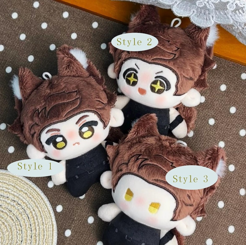 May include: Three plush dolls with brown fur, pointed ears, and black outfits. Each doll features distinct facial expressions and eye designs labeled Style 1, Style 2, and Style 3. The dolls have soft, fuzzy textures and are arranged together.