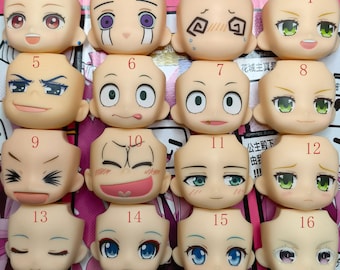 May include: A set of 16 plastic doll heads with different facial expressions. The heads are numbered 1 through 16 and are arranged in four rows of four. The heads are all the same size and shape, but they have different facial expressions, including smiling, frowning, surprised, and angry.