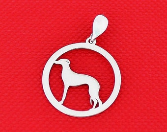 Puede incluir: Pendiente de plata con una silueta recortada de un galgo dentro de un círculo. El pendiente está sobre un fondo rojo.