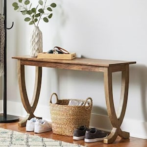 May include: An entrance hall with a wooden bench, black coat stand, and a woven basket. A patterned rug and a vase with greenery are also present. Shoes are placed near the bench, creating a homely feel.