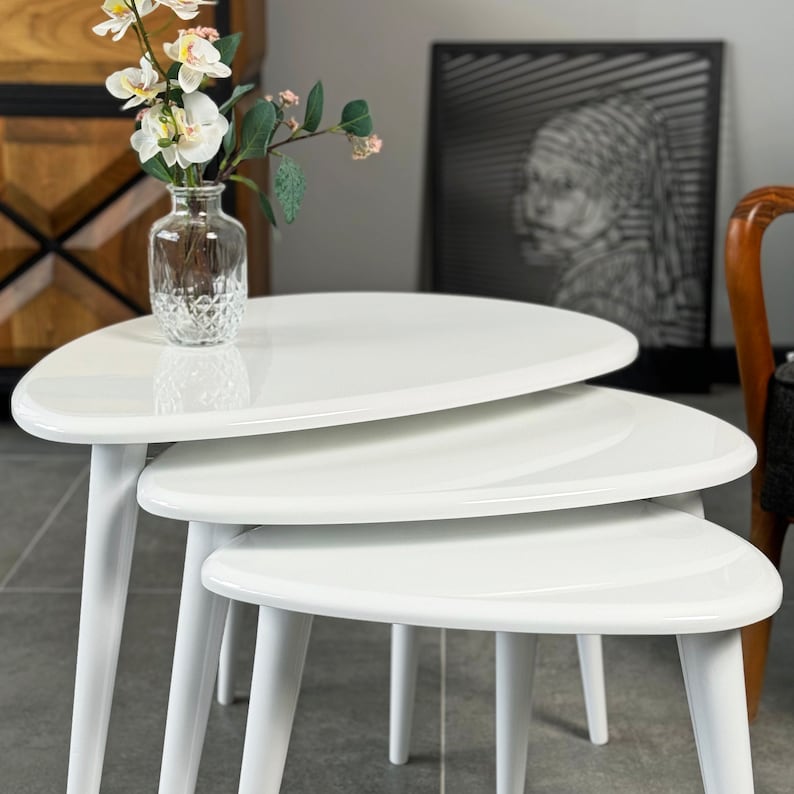 Puede incluir: Tres mesas nido blancas con forma ovalada redondeada. Las mesas est&aacute;n hechas de material blanco brillante y tienen un dise&ntilde;o moderno.