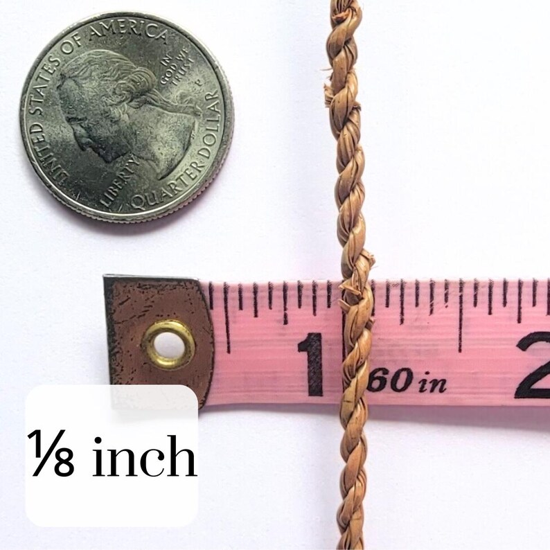 May include: Close-up of a twisted, natural-colored rope, approximately 1/8 inch in diameter, next to a quarter coin and a pink measuring tape. The tape reads 60 inches. The rope's texture is visible, suggesting a handmade or natural fiber product.
