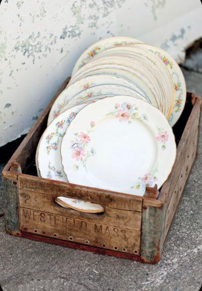 Assorted Vintage Mismatched China Plates sitting in a crate used at a wedding