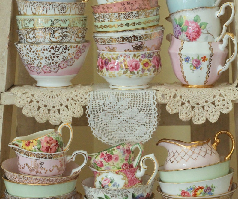 Vintage mismatched sugar bowls and creamers in a variety of sizes. Mostly floral patterns in pastel colors with gold or silver trim. Fancy china dishes used for parties and entertaining.