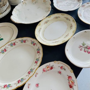 May include: A collection of vintage oval serving platters with floral patterns in shades of pink, blue, and green. The platters have gold trim and are perfect for serving a variety of dishes.