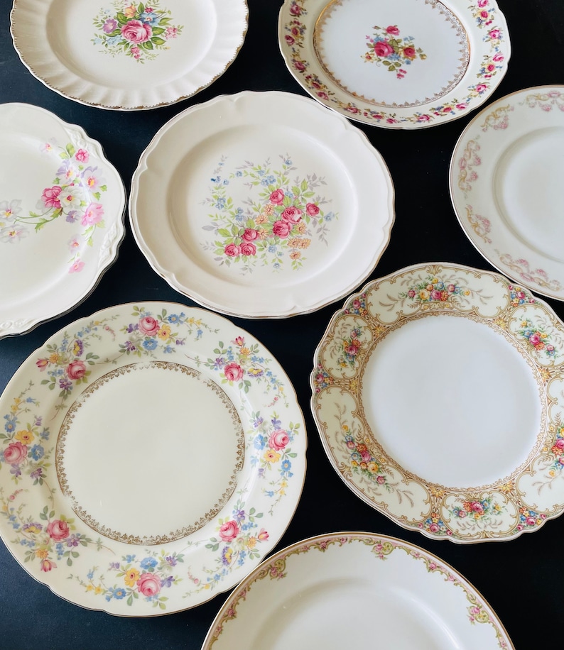 Vintage mismatched china plates with assorted floral designs.
