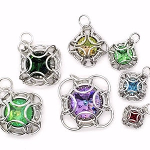 May include: Seven silver chainmaille pendants with different coloured gemstones. Each pendant features a square-shaped gemstone in the centre, surrounded by a silver chainmaille design.