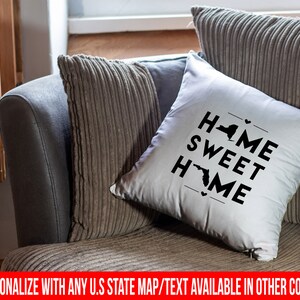 May include: White throw pillow with black text that reads "Home Sweet Home" and features the outlines of the states of New York and Florida.