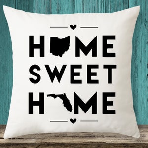 May include: White throw pillow with black text that reads "HOME SWEET HOME" with the state of Ohio and Florida in the middle of the text.