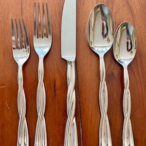 May include: Set of five silver-plated twisted cutlery pieces, including a knife, two forks, and two spoons.