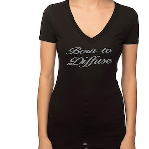 May include: Black v-neck t-shirt with the text "Born to Diffuse" in silver glitter lettering.