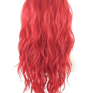 May include: A long, wavy, bright red wig. The wig is styled with loose, flowing curls.